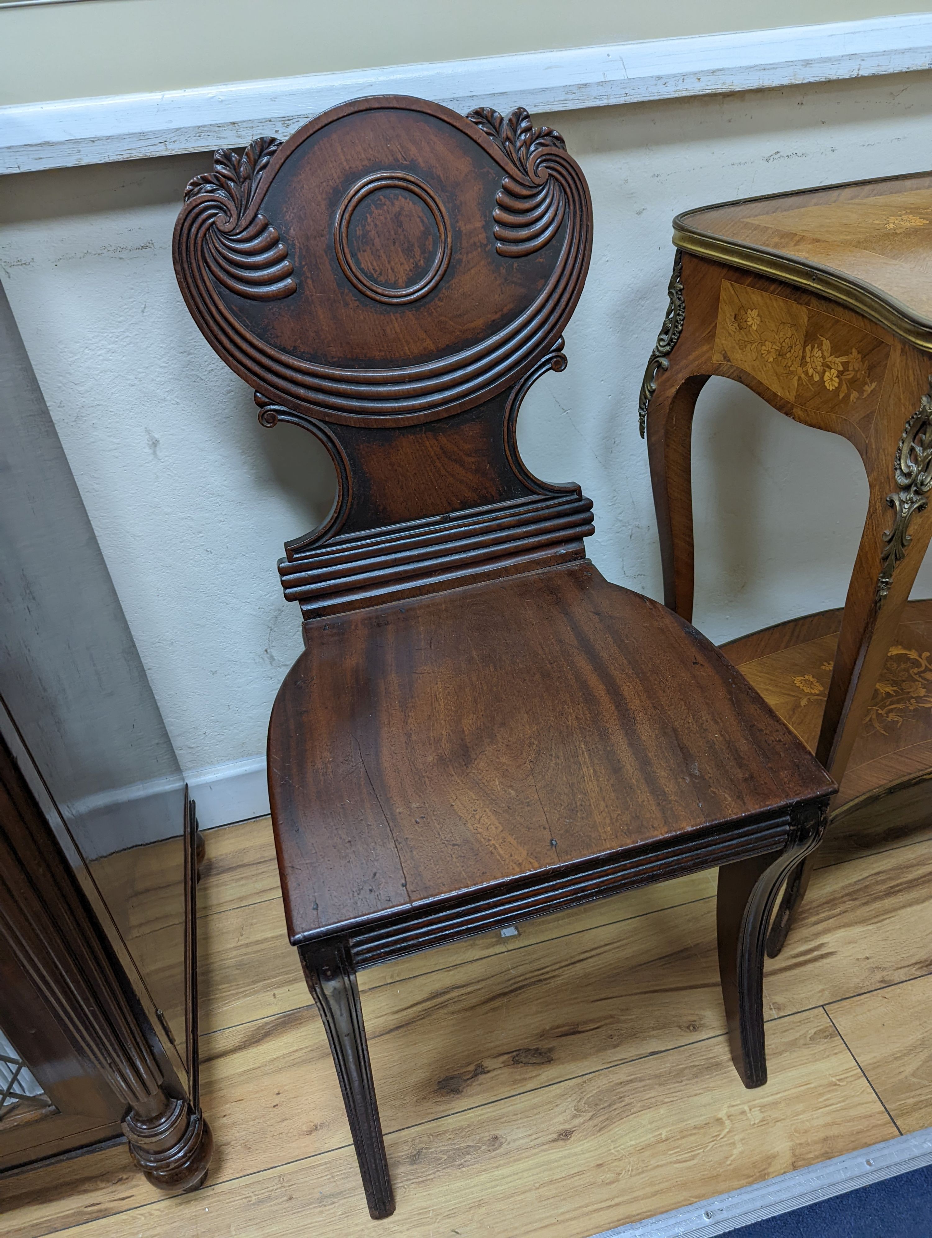 A pair of Regency mahogany sabre leg hall chairs